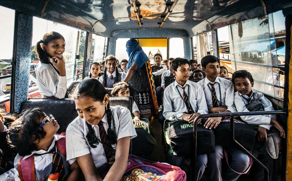 School children in uniform seated inside a bus