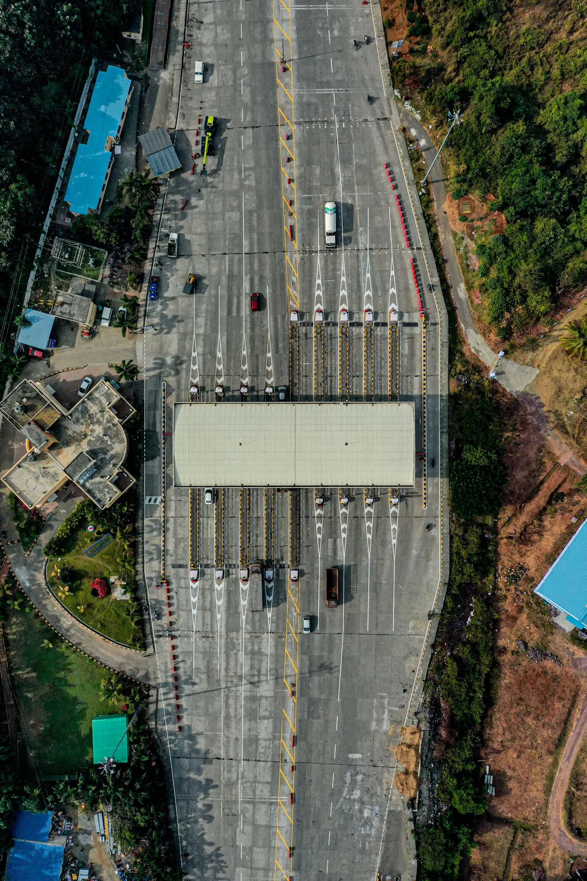 Aerial view of traffic queuing at a toll plaza between stands of trees
